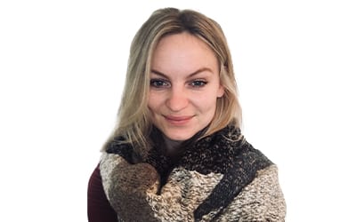 headshot of a blonde Caucasian female wearing a patterned scarf against an all-white background